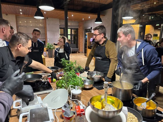 Engenious colleagues preparing a meal together at a cooking workshop